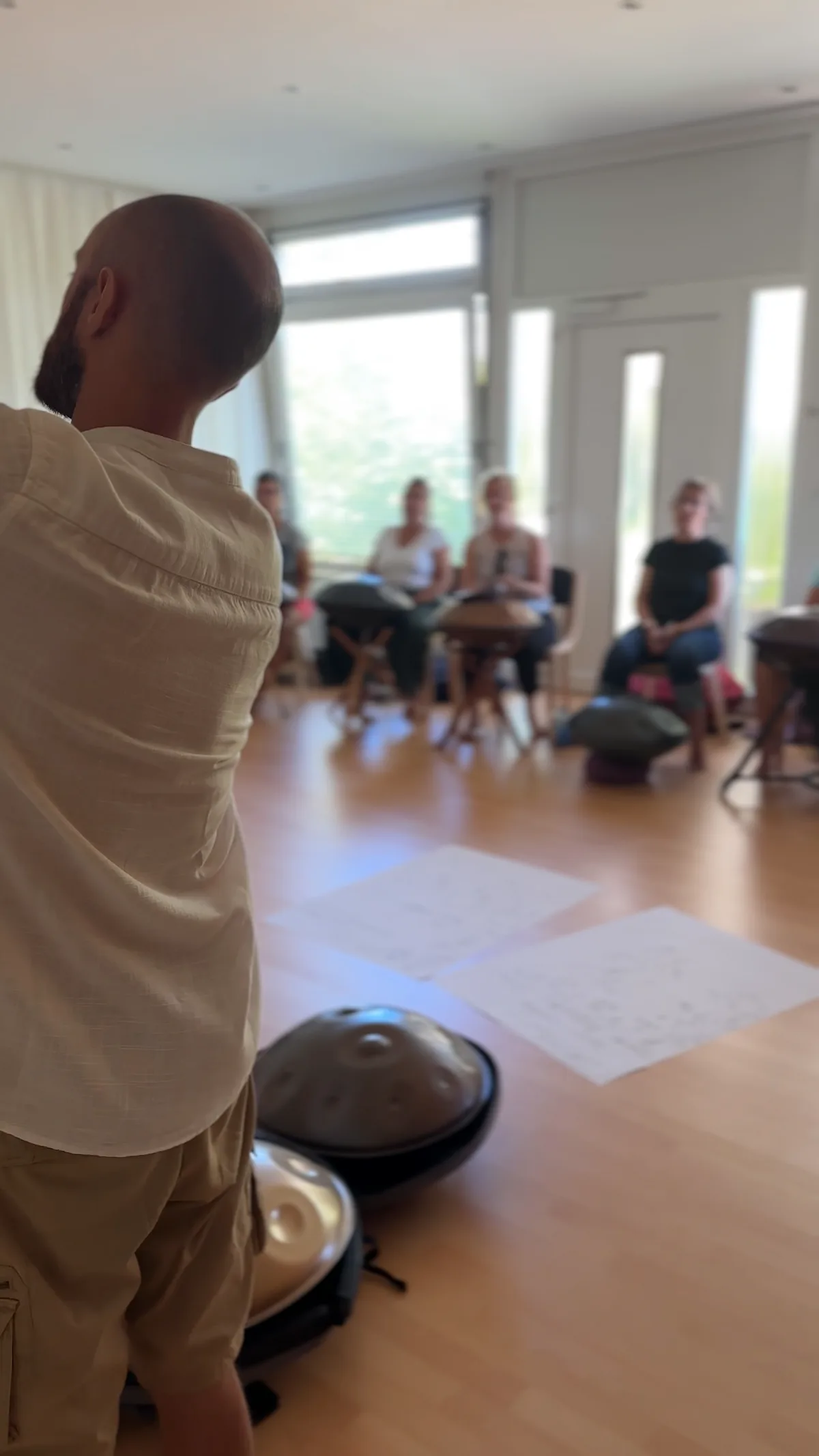 Amarok teaching a group of students seated with their handpans
