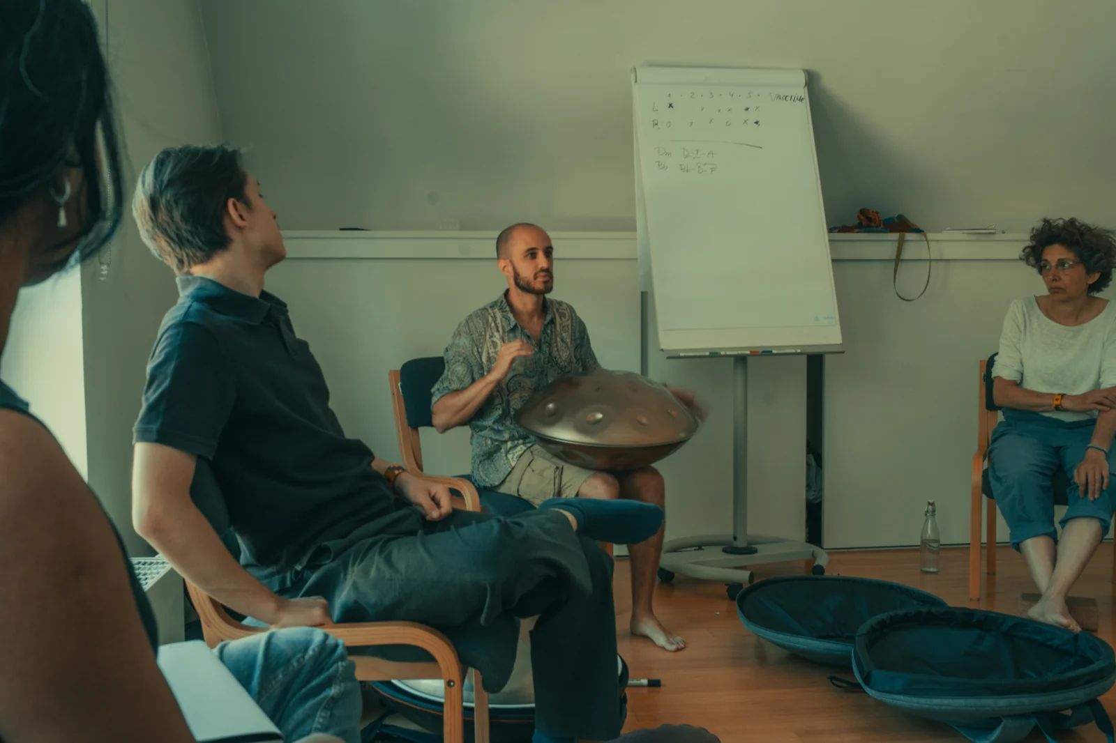 Amarok explaining a scale on a flipchart during a handpan workshop